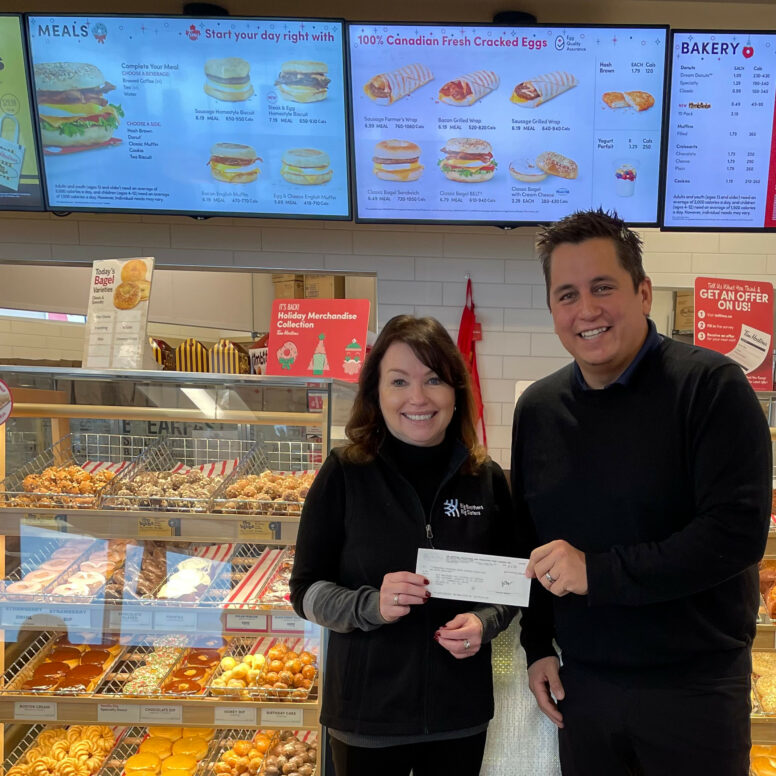 The manager of the Tk’emlúps Tim Hortons Joe Quewezance (right) presents Executive Director Helen Brownrigg (left) with a cheque for $17,785.00 from the Kamloops Smile Cookie Campaign.